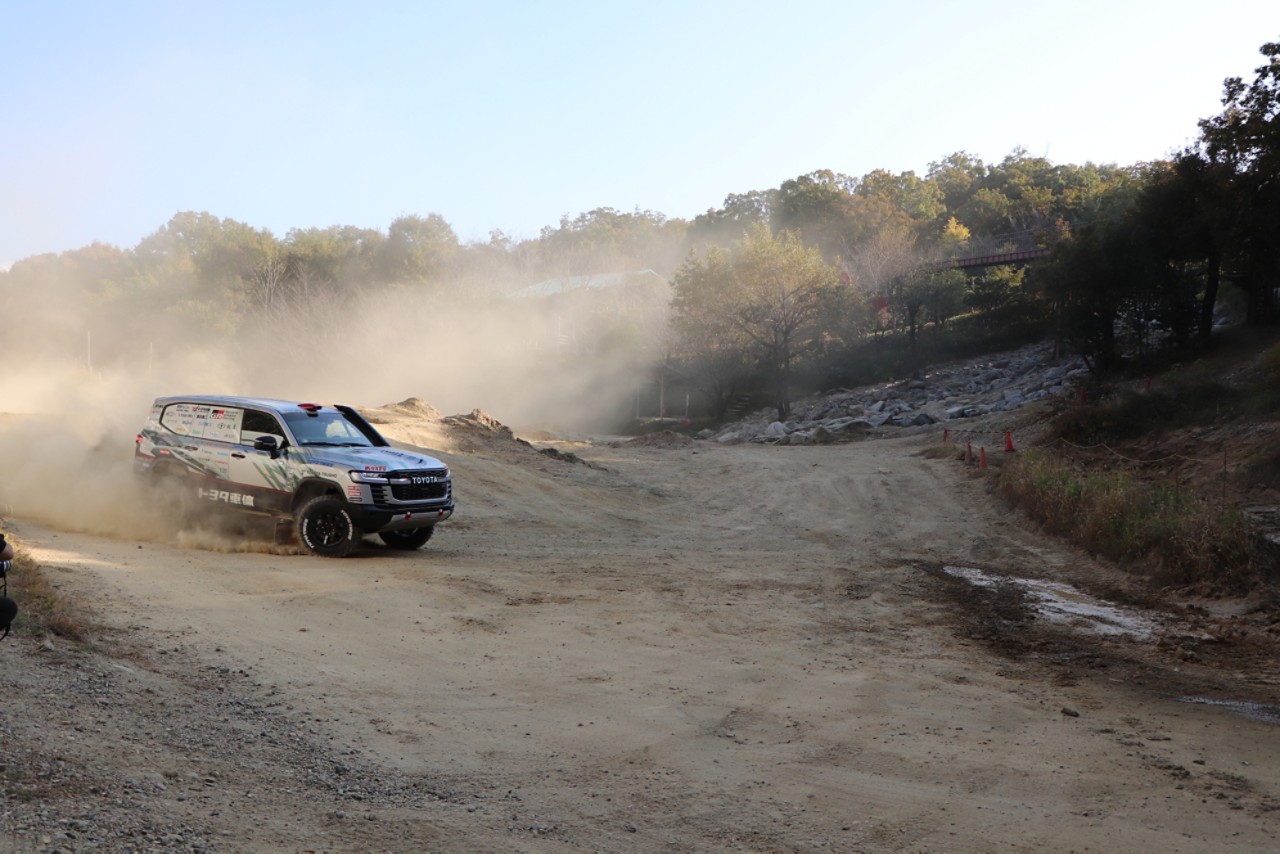 Landcruiser driving through off-road gravel surface kicking up dust