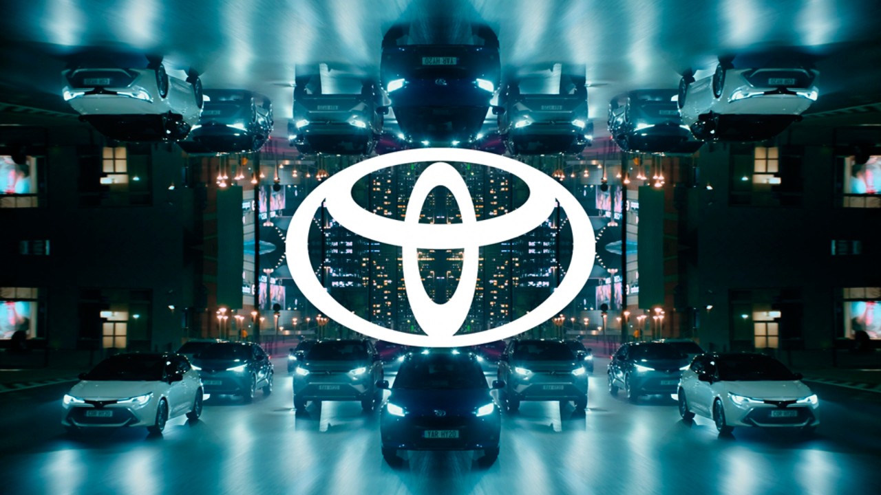 огледален изглед на автомобили в движение с центрирано Toyota лого