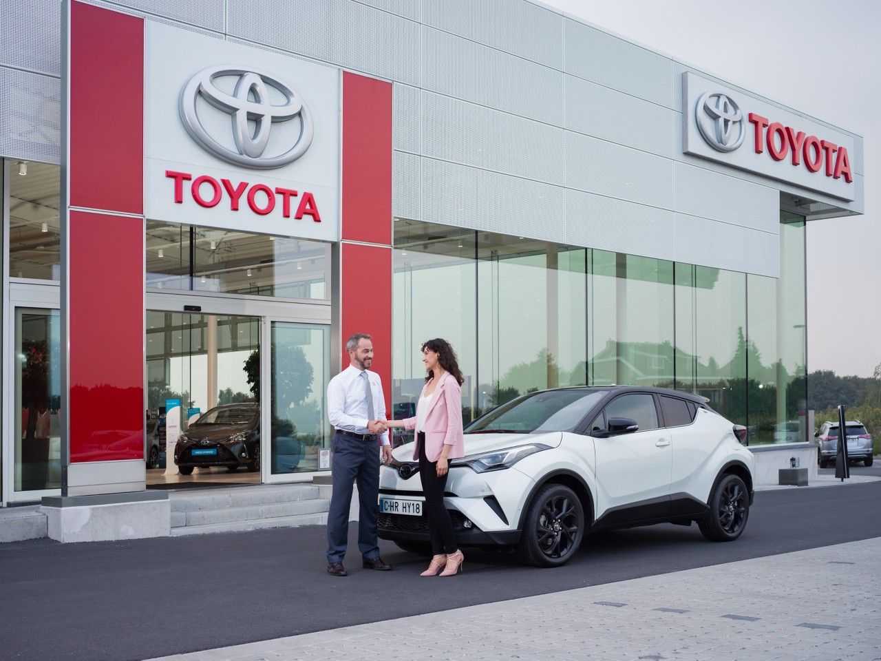 Toyota dealer and customer in front of a retailer shop
